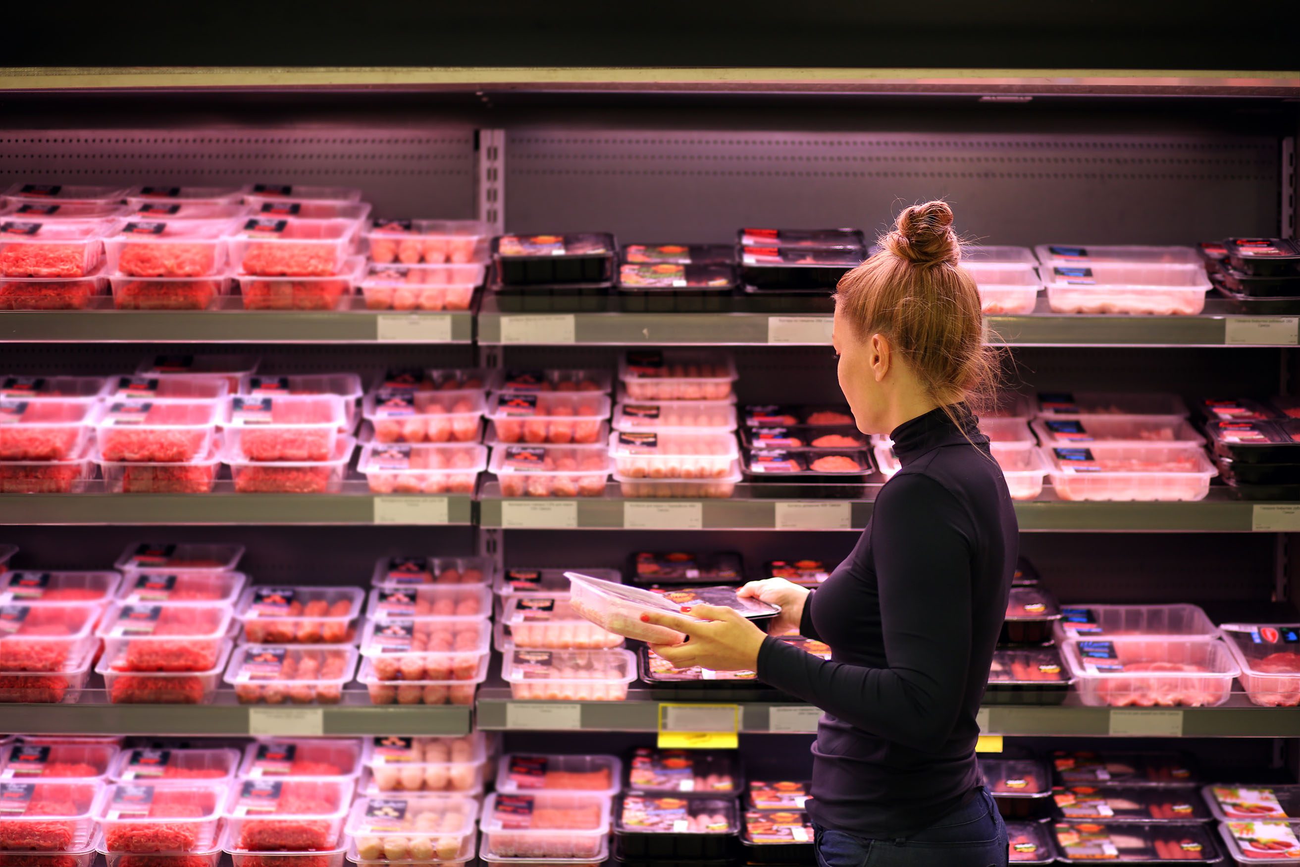 customer shopping in meat section of grocery store