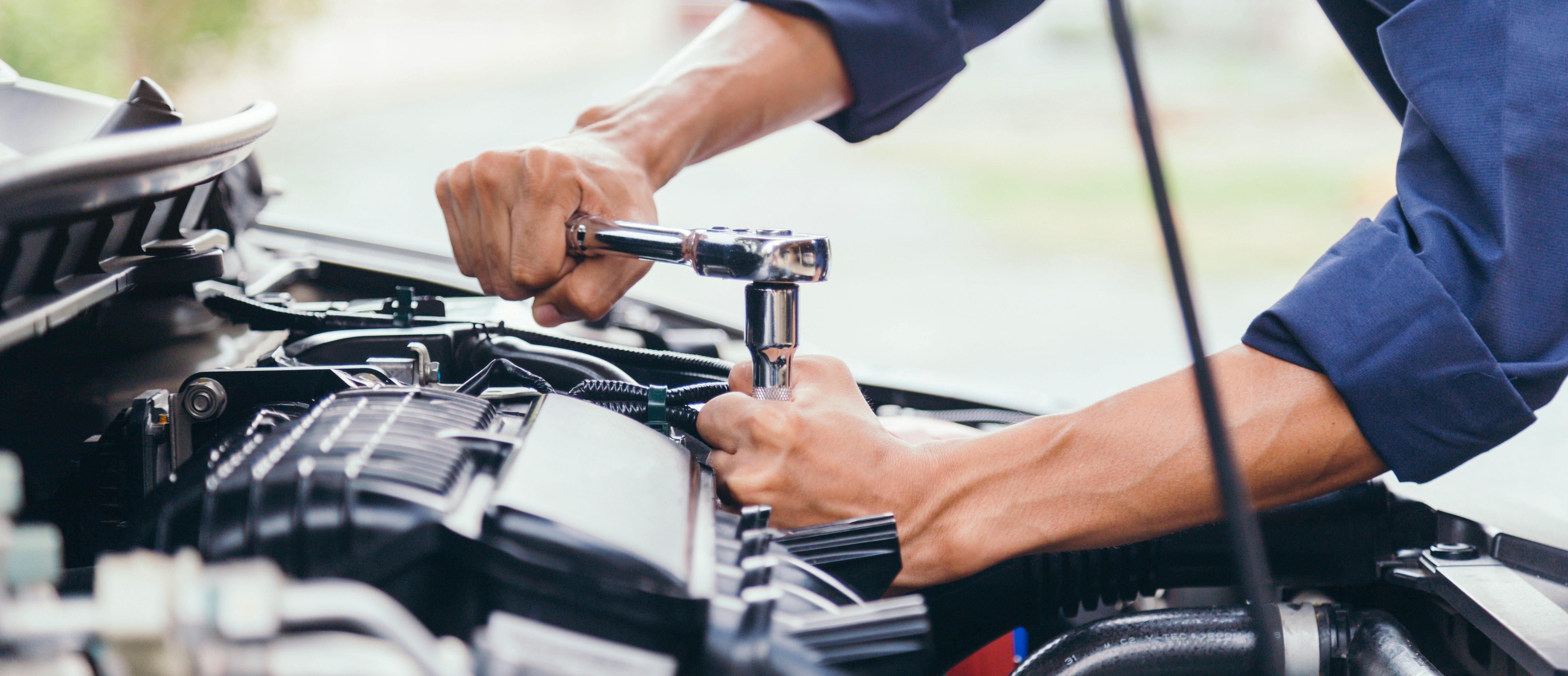 Automotive technician handling vehicle components in an automotive production setting