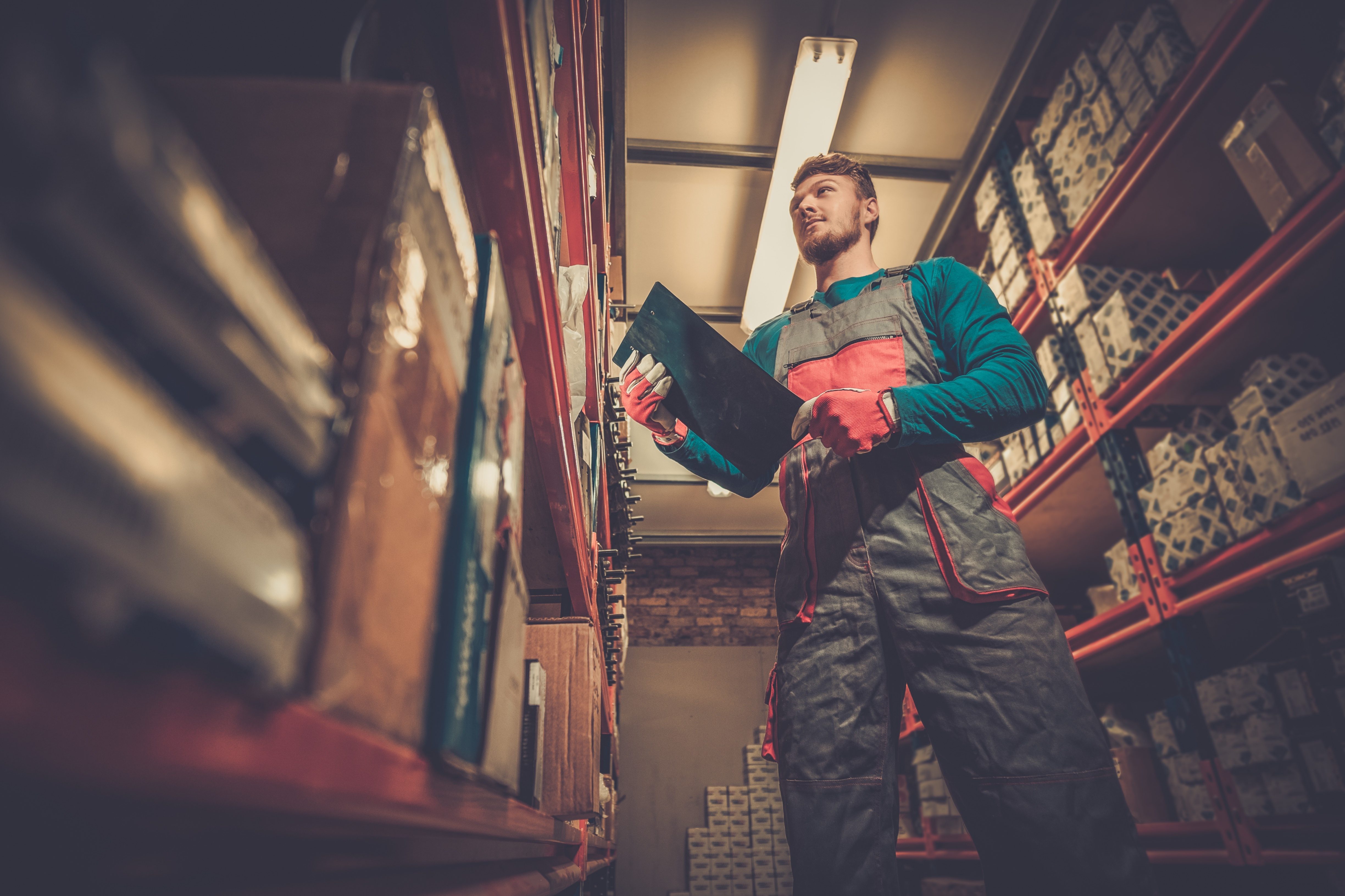 automotive warehouse employee selecting autoparts in varying packaging